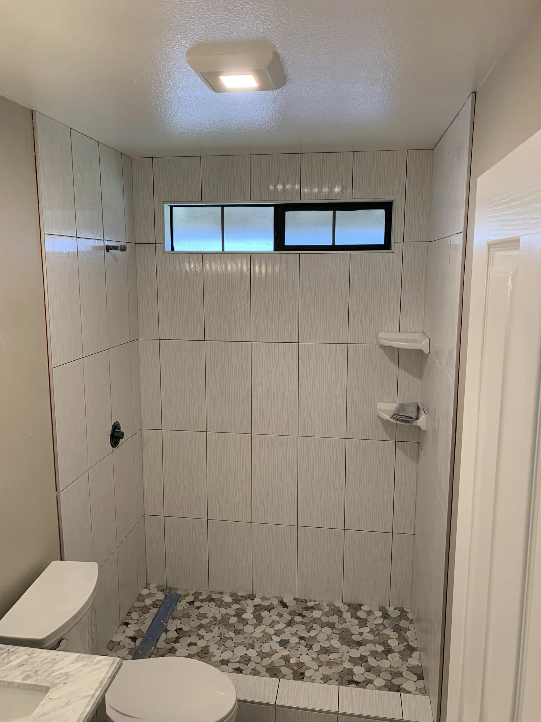 Pebble-floor shower: Tile set before the glass