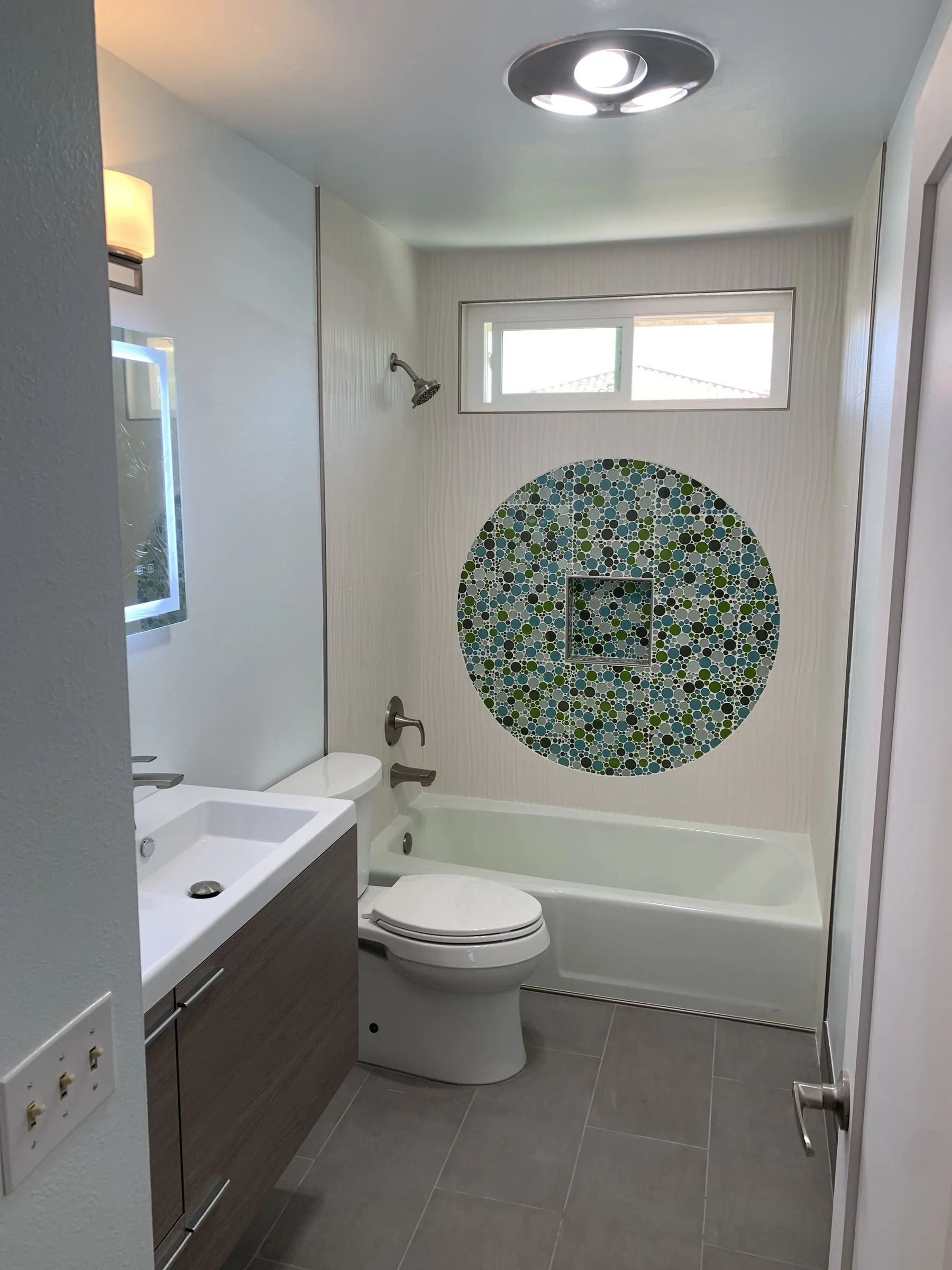 Finished bathroom with a round mosaic medallion set into the tub surround