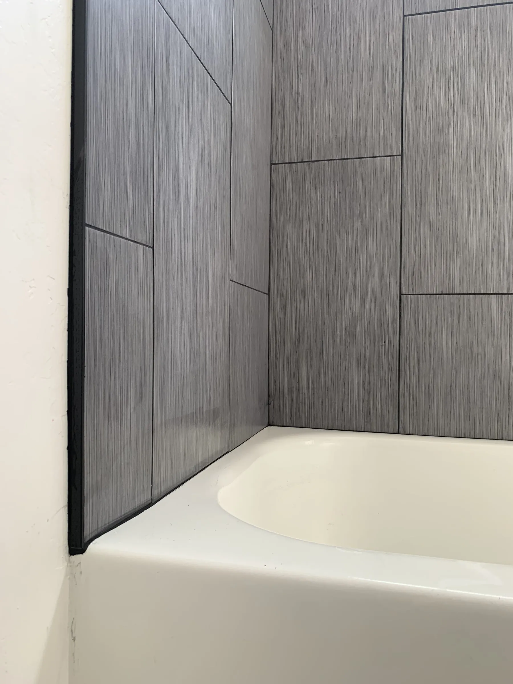 Charcoal tile tub surround: Large format tile going up